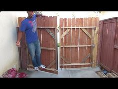 a man standing in front of a wooden gate