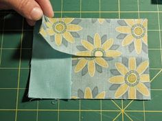 someone is making a flowered envelope out of fabric