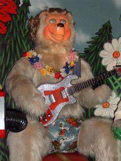 a stuffed animal plays an electric guitar