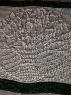 a crocheted blanket with the word love written in white and green on it