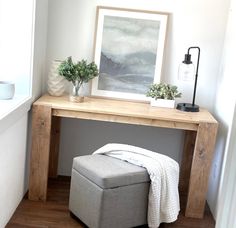 a bench with a blanket on it in front of a painting and potted plants