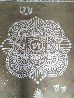 an intricate design on the ground with white paint and symbols drawn in it's center