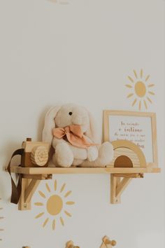 a stuffed animal sitting on top of a wooden shelf