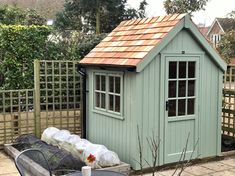 a small blue shed sitting next to a wooden fence