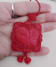 "A detailed and deeply carved classic cinnabar style pendant that is two-sided - a bold Chinese symbol on one side and a very charming Pekinese dog on the other. Just look at that fluffy pinwheel of a tail! The pendant measures 1 3/4\" square and the cord is 27\" long, so this is a moderately statement-sized necklace. Adds a little Asian flair to your black and white basics, particularly gorgeous on a black turtleneck for the upcoming season but versatile year round too. And that dog has such a Family Coloring, Chinese Symbols, Silk Cord, Black Turtleneck, Resin Necklace, Red Silk, Freshwater Pearl Necklaces, Asian Style, Create Image