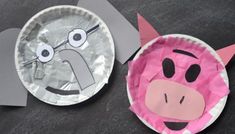 two paper plates that have some kind of animal face on them, one is pink and the other is gray