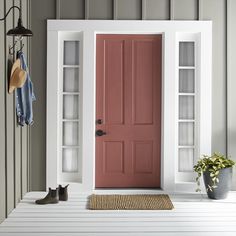 a blue front door with two shelves on either side and a potted plant next to it