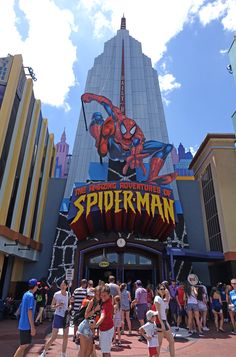 people are standing in front of the entrance to spider man