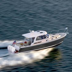 a small motor boat speeding across the water with an american flag on it's side