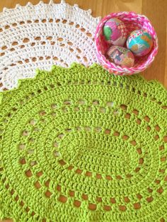 two crocheted doily with an easter egg in a bowl on the table