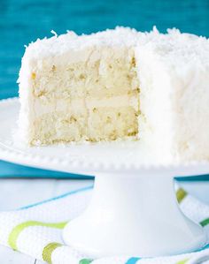 a white cake on a plate with a slice taken out of it's side