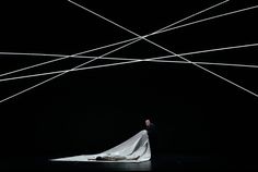 a man and woman standing in the middle of a dark room with white lines coming from them