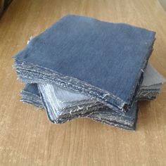 several pieces of blue jean sitting on top of a wooden table next to each other