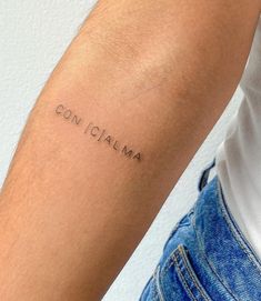 a person with a tattoo on their arm that says con cama in cursive writing