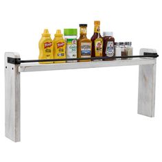 a shelf with bottles and condiments sitting on it's sides, in front of a white background