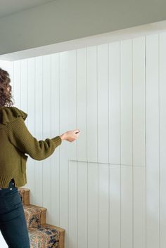 a woman writing on the wall with a marker