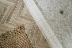 the bathroom floor is made up of wood planks and white tile, along with a rug on the floor