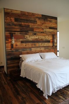 a large bed sitting in the middle of a bedroom next to a wall made out of wood planks