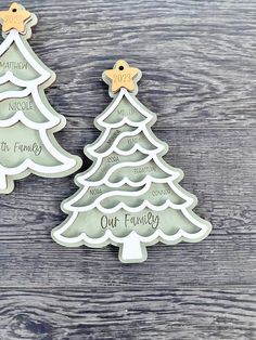 two christmas tree shaped cookie cutters on top of a wooden table next to each other