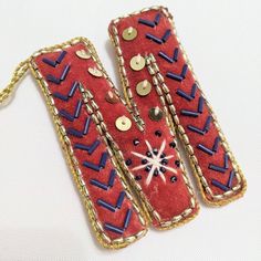 two pieces of red fabric with gold chains and buttons on them are laying side by side