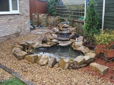 a backyard pond with rocks and water features