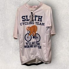 a white shirt with a brown bear on the front and words that read, sloth cycling team we'll get there when we get here