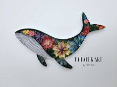 a paper whale with colorful flowers on it's tail and the words flafak art above it