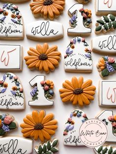 decorated cookies with numbers and flowers are arranged on a white tablecloth that says welcome