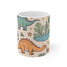 a coffee mug with dinosaurs and plants on the inside, sitting in front of a white background