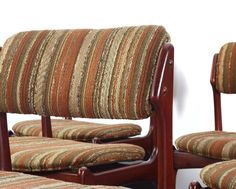 two wooden chairs with striped upholstered seats and back cushions, side by side