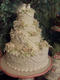 a wedding cake with flowers and birds on top