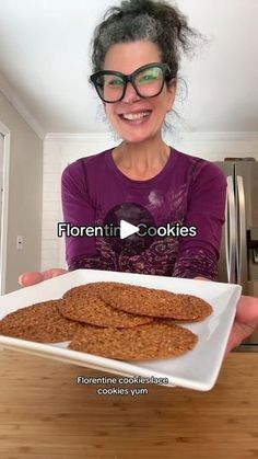 a woman holding a plate of cookies in front of her face with the words florentii cookies on it