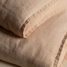 two linen pillows stacked on top of each other