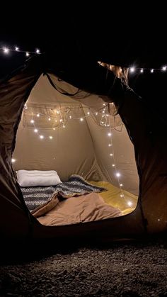 a tent is lit up with fairy lights