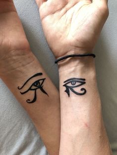 two wrist tattoos with an egyptian eye on them