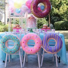 a table with donuts and balloons on it