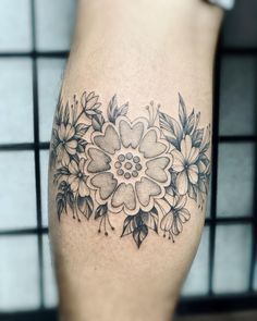 a close up of a person's leg with a flower tattoo design on it