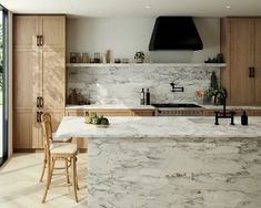 a kitchen with marble counter tops and wooden cabinets, along with an island in the middle