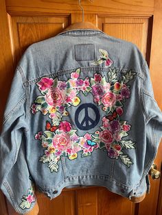 a denim jacket with flowers and peace on it