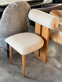 a pair of chairs sitting next to each other on top of a floor covered in plastic