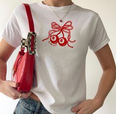 This Y2K baby tee is the ultimate blend of coquette charm and nostalgic vibes, featuring a playful "Lucky Girl" graphic paired with adorable coquette cherries. Perfect for fans of cottagecore and cinnamon girl aesthetics, this cherry t-shirt brings a touch of retro flair to your wardrobe. With its Gen Z-friendly design and classic 90s crop top fit, this shirt seamlessly combines the best of Y2K fashion with contemporary style, making it a must-have for anyone looking to embrace the essence of co Y2k T-shirt With Cherry Print, Trendy Red Top As A Gift, Retro Tops With Funny Print As Gift, Red T-shirt For Spring, Red T-shirt For Spring Gift, Retro Short Sleeve T-shirt As Gift, Retro Short Sleeve T-shirt As A Gift, Retro Short Sleeve Tops As Gift, Retro Short Sleeve T-shirt For Gifts