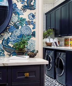 a washer and dryer in a room with blue flowers on the wall behind it