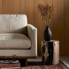 a white couch sitting next to a wooden table on top of a carpeted floor