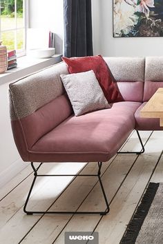 a living room with a pink couch and coffee table