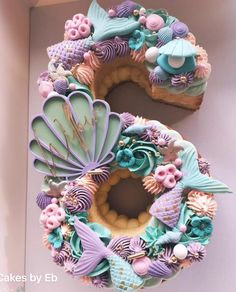 there is a number made out of cookies with mermaid decorations on top and under it