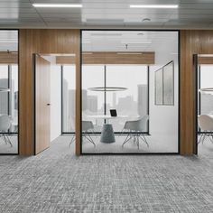 an office with glass walls and white chairs