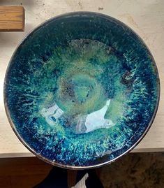 a blue and green bowl sitting on top of a table