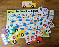 children's board game with cars and bus on wooden table next to cut outs