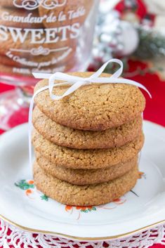 a stack of cookies sitting on top of a white plate next to a glass jar