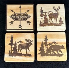 four wooden coasters with moose and bear designs on them, one has the words welcome to the hunting cabin